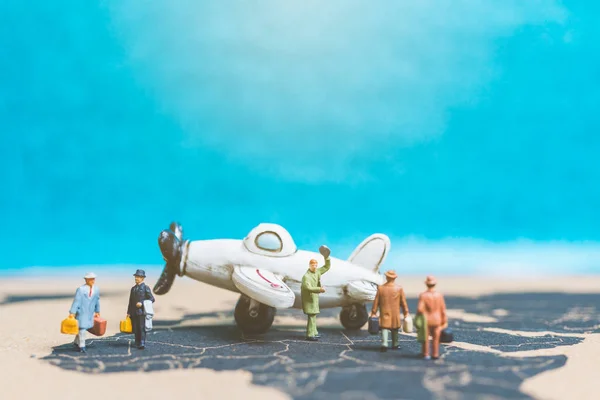 Miniaturmenschen: Reisende mit Flugzeug auf der Weltkarte — Stockfoto