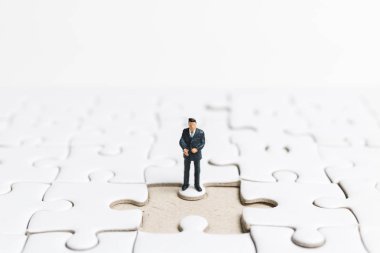 Minyatür insanlar: işadamı üzerinde beyaz jigsaw ayakta. 