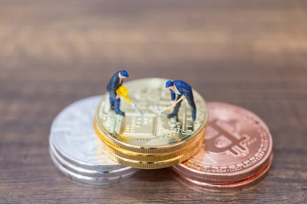 Pessoas em miniatura: Equipe de trabalhadores fazendo Bitcoin moeda na forma de digital (Criptomoeda ) — Fotografia de Stock