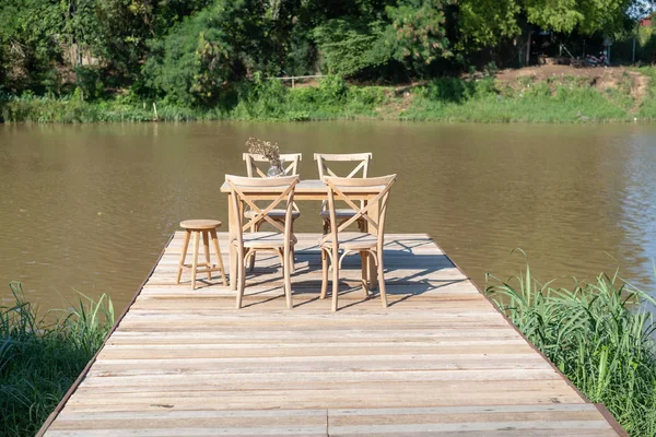 Mesa e cadeira na longa ponte de madeira — Fotografia de Stock