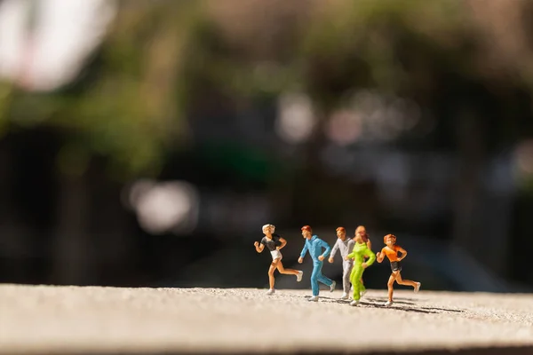 Pessoas em miniatura: Grupo de pessoas estão correndo em estrada de concreto — Fotografia de Stock