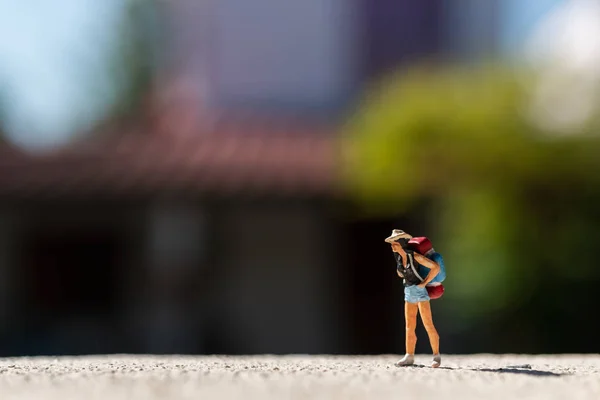 Miniaturmenschen: Reisende mit Rucksack steht auf der Straße — Stockfoto