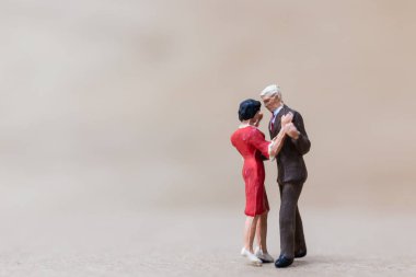 Minyatür insanlar, ahşap arka planda dans eden çift.