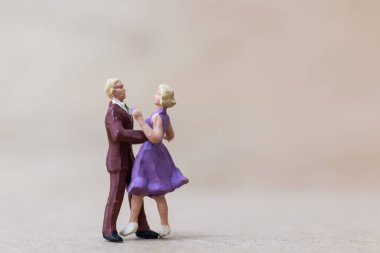 Minyatür insanlar, ahşap arka planda dans eden çift.