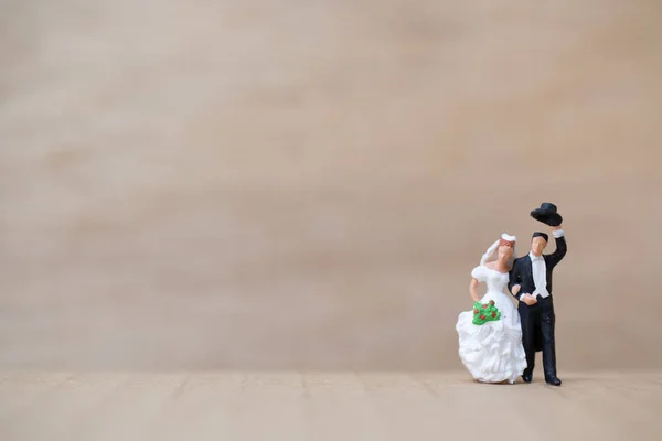 Miniaturmenschen: Braut und Bräutigam auf hölzernem Hintergrund mit Kopierraum für Text — Stockfoto
