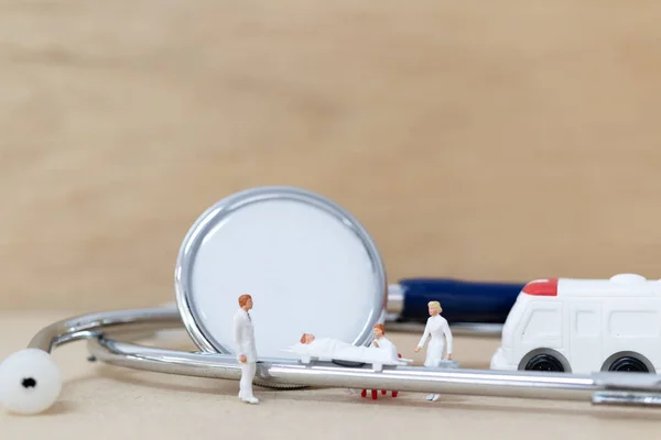 Pessoas em miniatura: Doutor com enfermeira carrega o paciente em uma maca — Fotografia de Stock