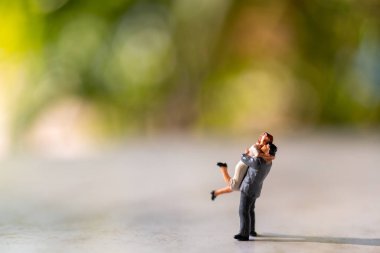 Minyatür insanlar: Gelin ve damat açık havada yeşil bokeh arka planda ve metin için boşluk kopyala