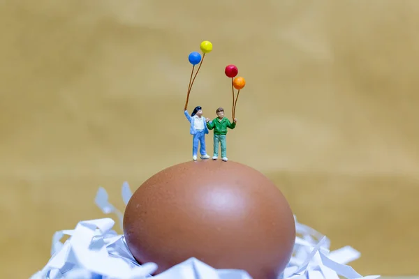 小人物：快乐的家庭抱着气球庆祝复活节彩蛋 — 图库照片