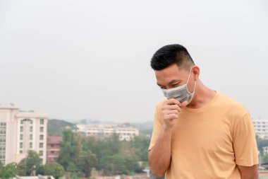 Yüz temizleme maskesi takan Asyalı adam. Virüs koruması, Hava kirliliği, konsept