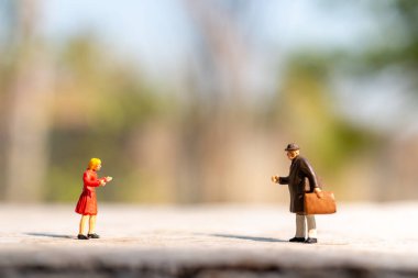 Minyatür insanlar COVID-19 koronavirüs salgınından korunmak için sosyal mesafeyi korumak için selamlıyorlar.