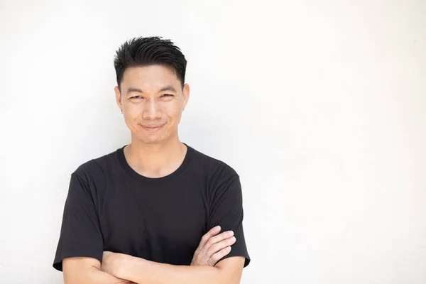 Portrait of Young asian man standing on white wall background