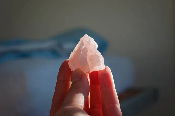Holding a healing rose crystal or a gemstone. A lovely pink love stone isolated bring good vibes and positive vibrations — Stock Photo, Image