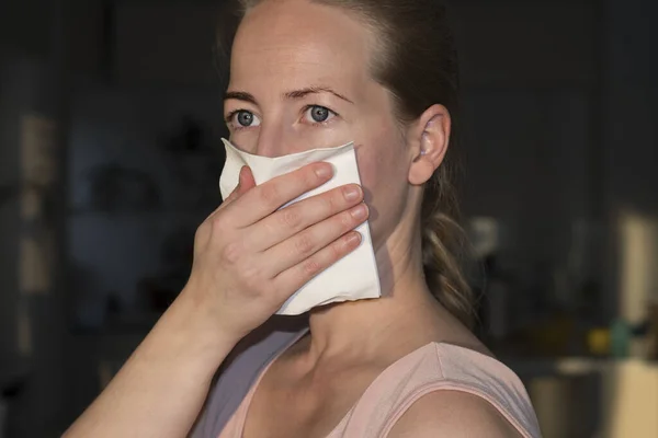 Protect from Coronavirus. A Scandinavian woman protecting her mouth to stop corona virus outbreak. Corona virus and epidemic virus symptoms from Wuhan