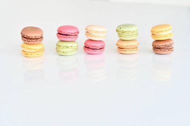 Beyaz arka planda pasta ya da badem kurabiyesi, çeşitli pastel renklerde tatlı ve renkli badem kurabiyeleri, klasik görünüm. Farklı türde badem kurabiyeleri lezzetli bir tatlıdır..