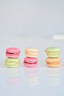 Beyaz arka planda pasta ya da badem kurabiyesi, çeşitli pastel renklerde tatlı ve renkli badem kurabiyeleri, klasik görünüm. Farklı türde badem kurabiyeleri lezzetli bir tatlıdır..