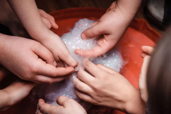 Baby hands in foam. Children play with foam