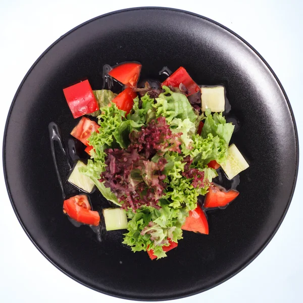 The salad of the robe on a black plate — Stock Photo, Image