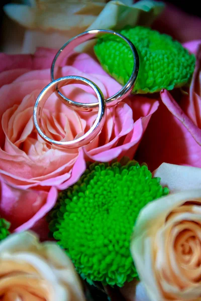 Bröllopsringar på en bukett rosor — Stockfoto