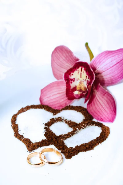 Obrączki ślubne, czułe orchidee i serca do kawy — Zdjęcie stockowe