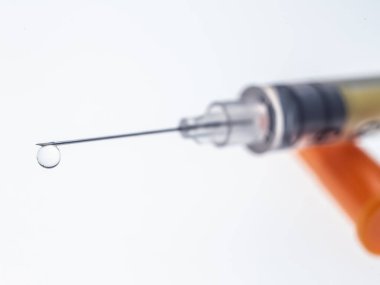 Beyaz arka planda bir damla ile insülin şırıngası