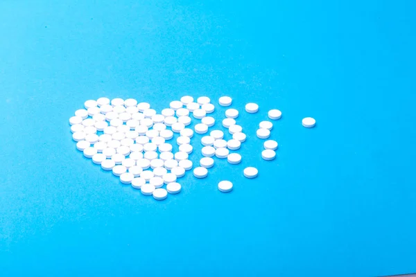 Heart of pills on a blue background