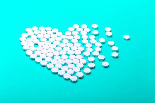 Heart of pills on a green background