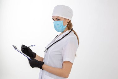 Beyaz önlüklü doktor notlar alır.