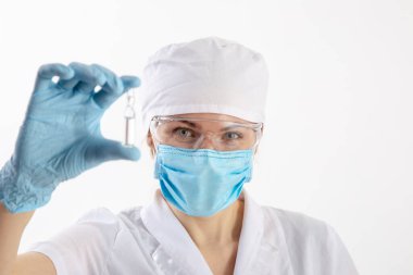 Beyaz önlüklü bir doktor ilaçlara bakar.