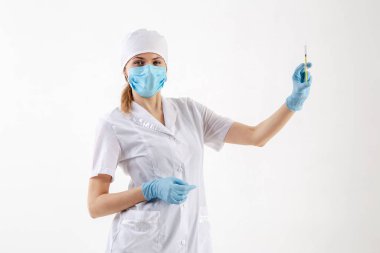 Beyaz önlüklü doktor elinde şırınga tutuyor.