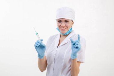 Beyaz önlüklü doktor elinde şırınga tutuyor.