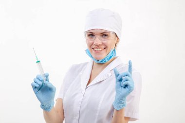 Beyaz önlüklü doktor elinde şırınga tutuyor.