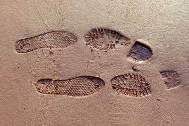 Islak kumda bir erkek ve bir kadının izleri..