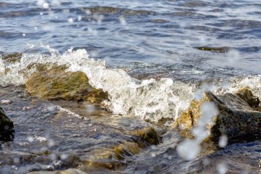 Rocky nehir kıyısı. Dalgalar kayalara karşı yükselir