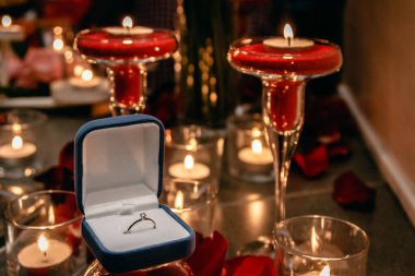 Mumların arasında nişan yüzüğü olan bir kutu..