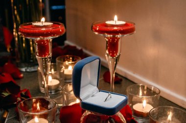 Mumların arasında nişan yüzüğü olan bir kutu..