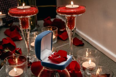 Mumların arasında nişan yüzüğü olan bir kutu..