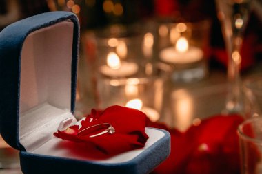 Mumların arasında nişan yüzüğü olan bir kutu..