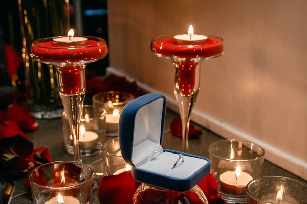 Mumların arasında nişan yüzüğü olan bir kutu..