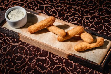 Ahşap tabakta soslu kızarmış peynir.