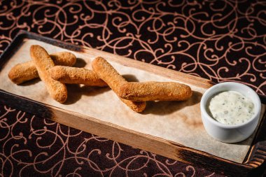 Ahşap tabakta soslu kızarmış peynir.