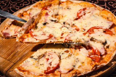 Peynirli, mantarlı ve sosisli pizza.