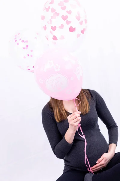 Young pregnant woman sitting with balloons - Gender Reveal - It' — ストック写真