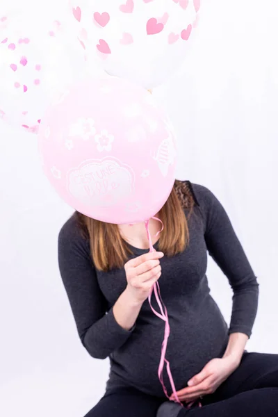 Young pregnant woman sitting with balloons - Gender Reveal - It' — ストック写真