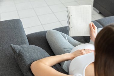 Genç hamile bir kadın tarafsız bir defter tutuyor. 