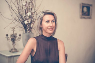 Kafede ya da restoranda oturan güzel sarışının tonlu resmi.