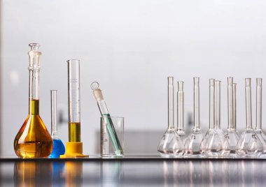 Gerçek bir laboratuvarda renkli reaktör çözeltileri olan bir kavanoz ve matara seti. Metin yerleştirme için büyük boş boşluk.