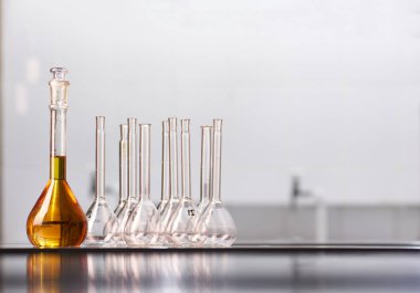 Gerçek bir laboratuvarda renkli reaktör çözeltileri olan bir kavanoz ve matara seti. Metin yerleştirme için büyük boş boşluk.