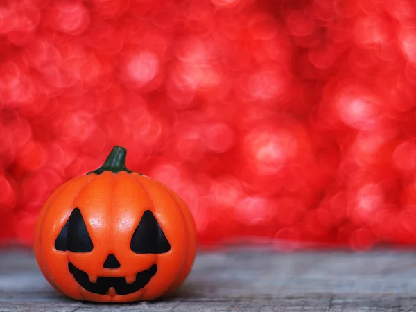 Halloween labu di meja kayu atas bokeh merah backgroun — Stok Foto