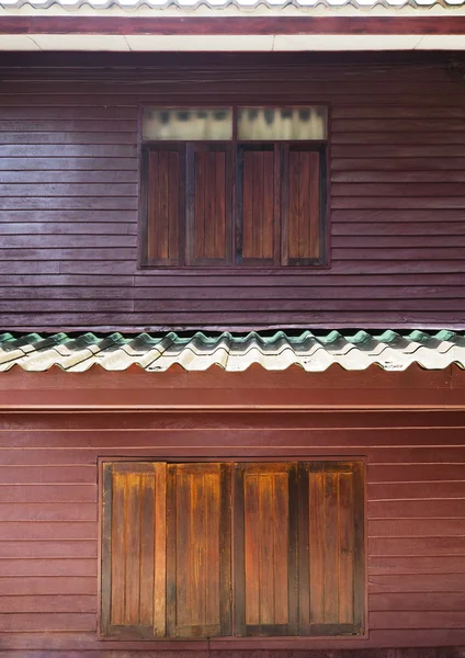 Дерев'яні вікна старовинного двоповерхового будинку — стокове фото