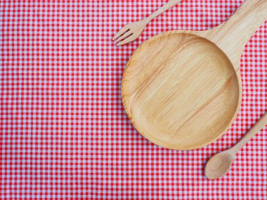 Boş tabak ve kaşık kırmızı işaretli masa örtüsü üzerinde